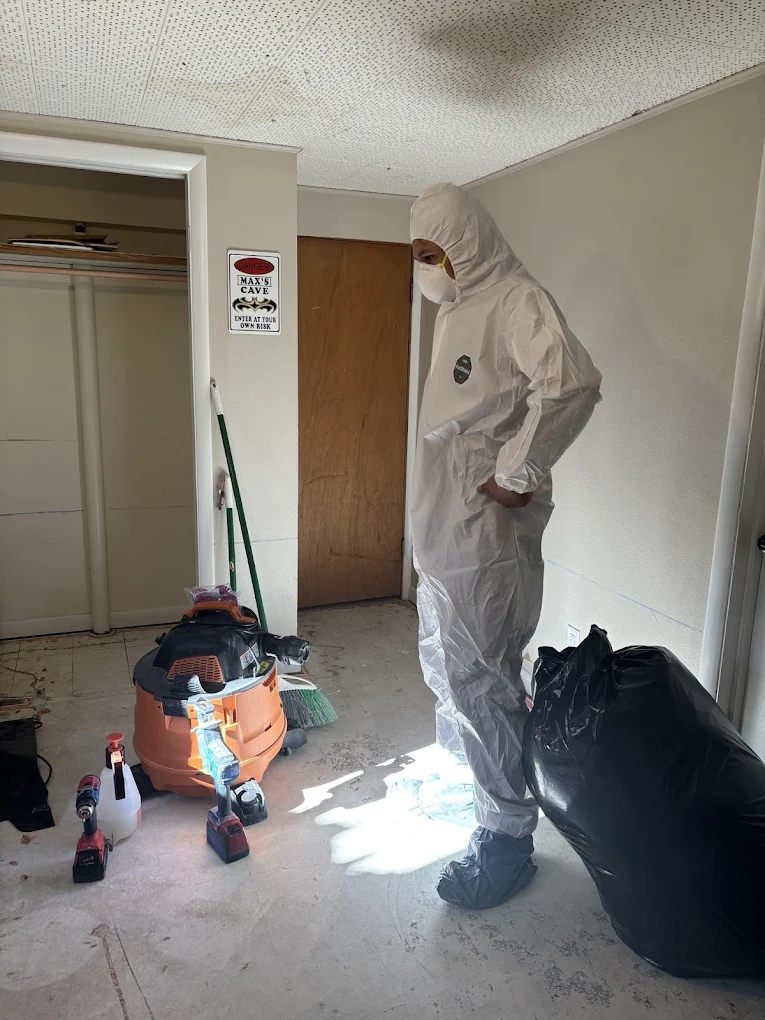 BORLakewood - About Us Person in hazmat suit cleaning a room.