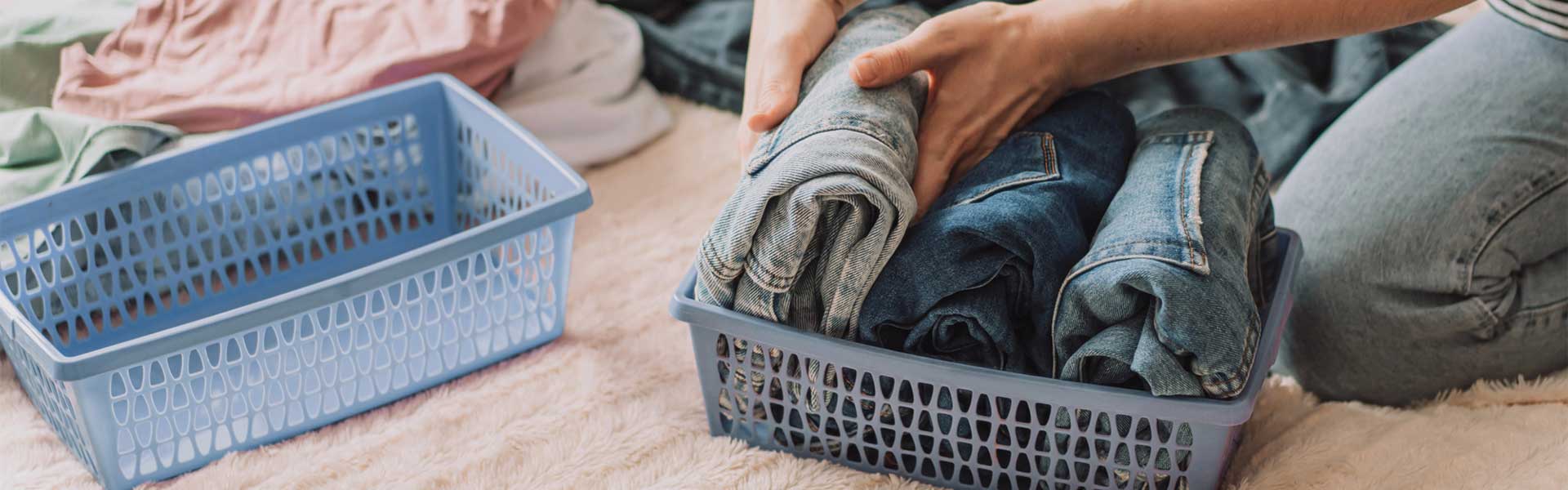 Folding jeans into blue baskets - Contents & Personal Property Restoration