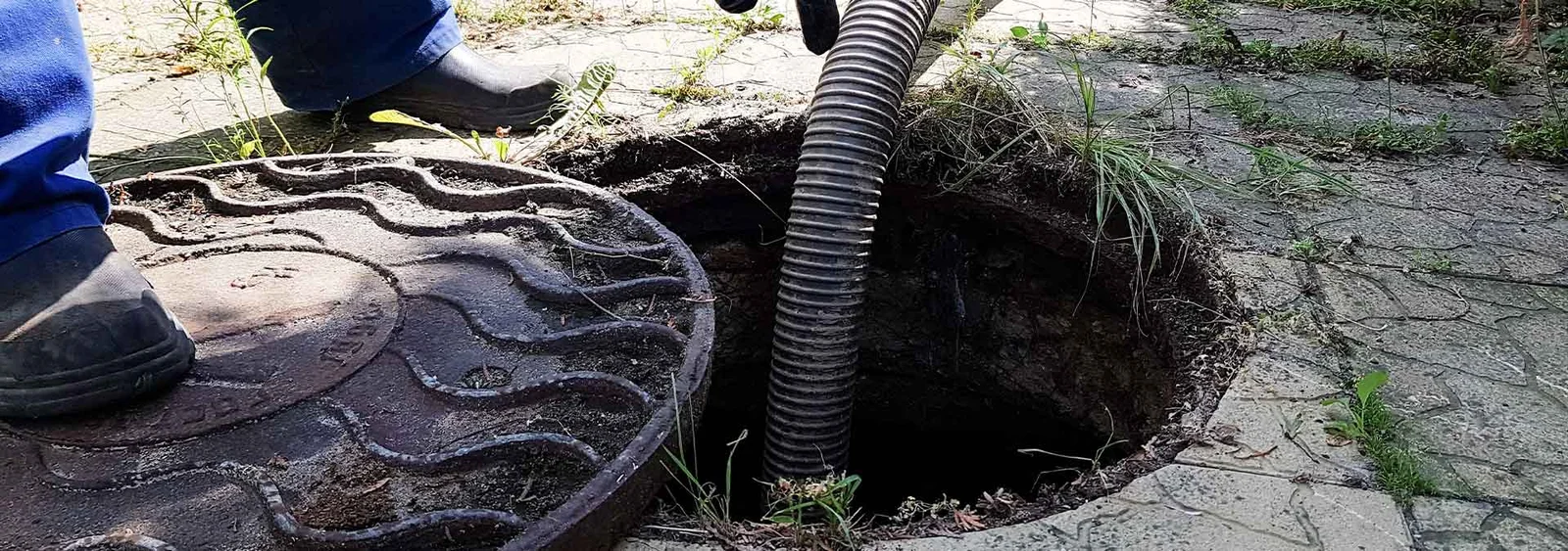 Worker cleaning an outdoor septic tank.