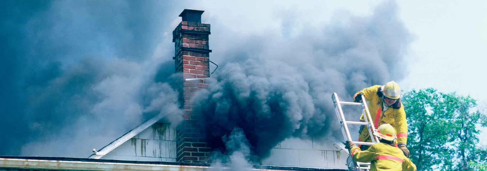 Firefighters on roof with heavy smoke